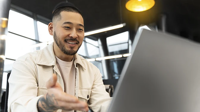 Homem asiático tatuado e feliz fazendo curso de e-learning corporativo